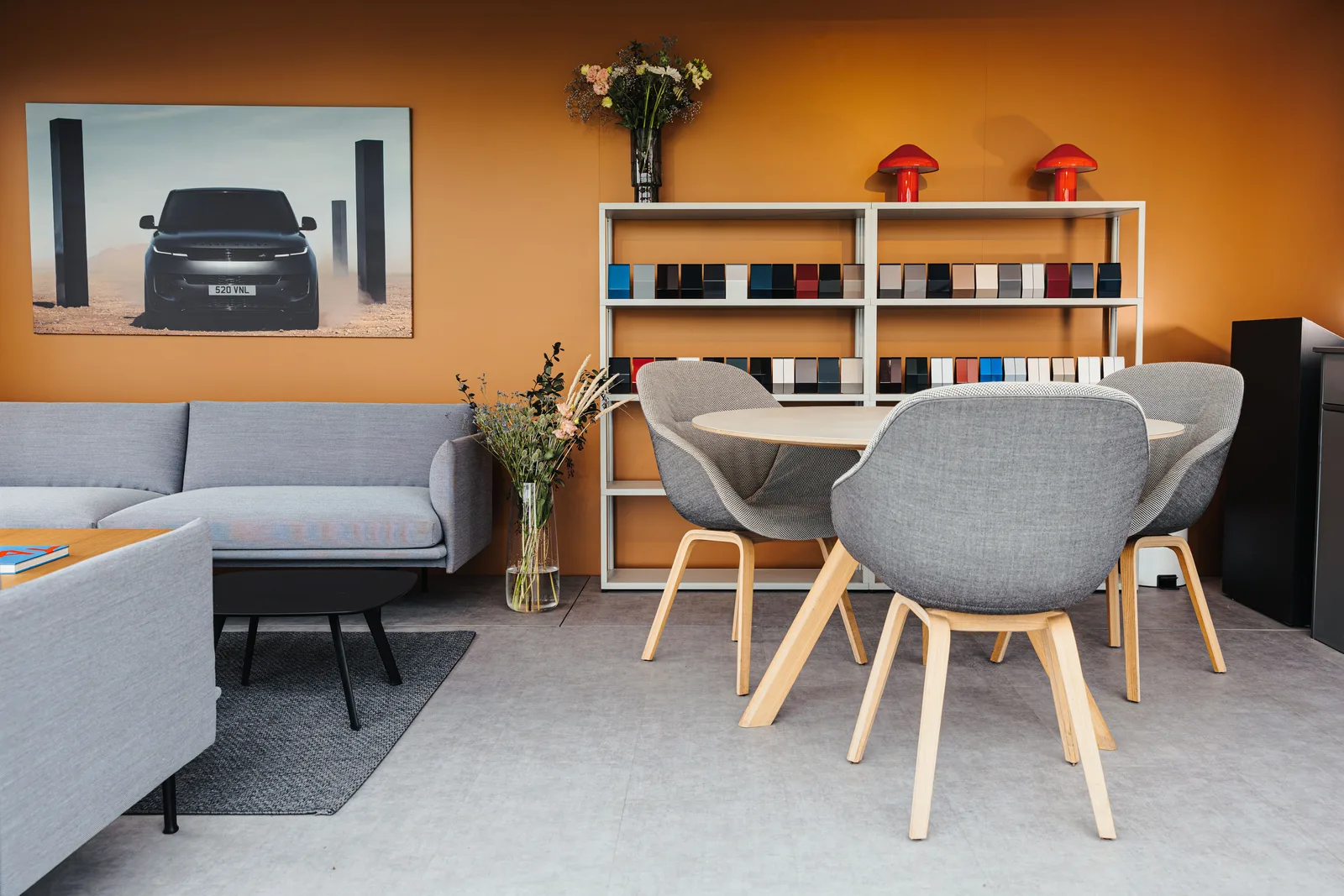 The lounge inside: sofas, a table and a wall of orange